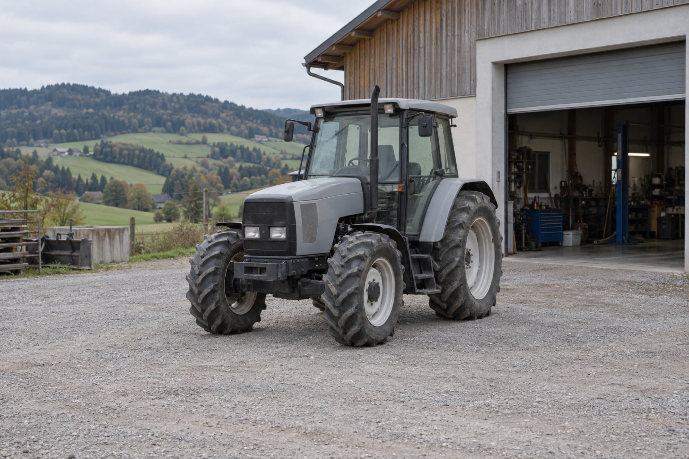 Traktor vor der offenen Werkstatthalle